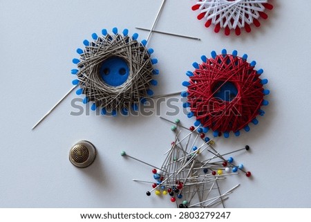 Various sewing supplies, Sewing thread spools, sewing needles, pins and thimble
