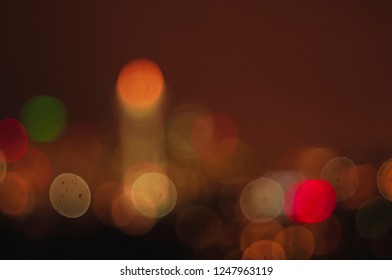 Various sized sharp round bokeh of the city of Seattle skyline at sunset with Space Needle against reddish sky