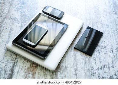 Various Smartphones, A Laptop And Tablet Pcs On A Wooden Table.
