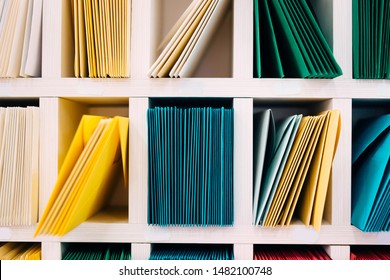 Various Sort Mail Envelopes Arranged On A Shelf By Color And Type Categories.  Front View.