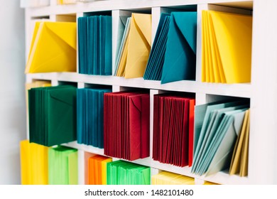 Various Sort Mail Envelopes Arranged On A Shelf By Color And Type Categories. 