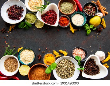 Various spices in a bowls on black concrete background. Top view copy space.