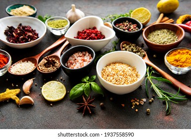 Various spices in a bowls on black concrete background. Top view copy space.