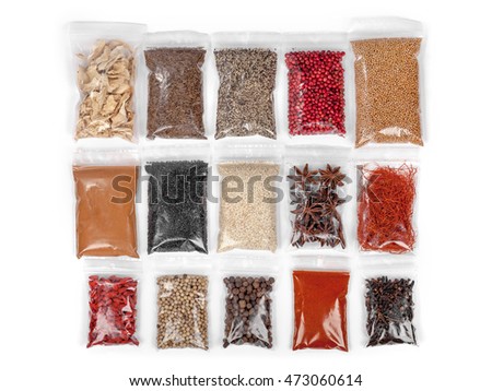 various spices and herbs packed in small transparent plastic bags on white background