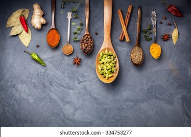 Various Spices like turmeric, cardamom, chili, bayberry, bay leaf, ginger, cinnamon, cumin, star anise on grunge background with space for your text
