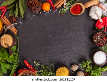 Various spices on black stone shot from aerial view