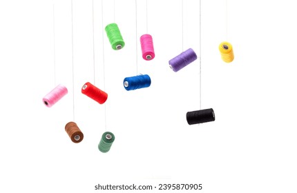 Various spools of sewing cotton thread of different colors floating.