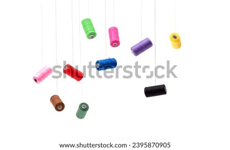 Various spools of sewing cotton thread of different colors floating.