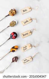 Various Spoons Filled With Ingredients Commonly Used In Making Smoothie Bowls Or Trail Mix.