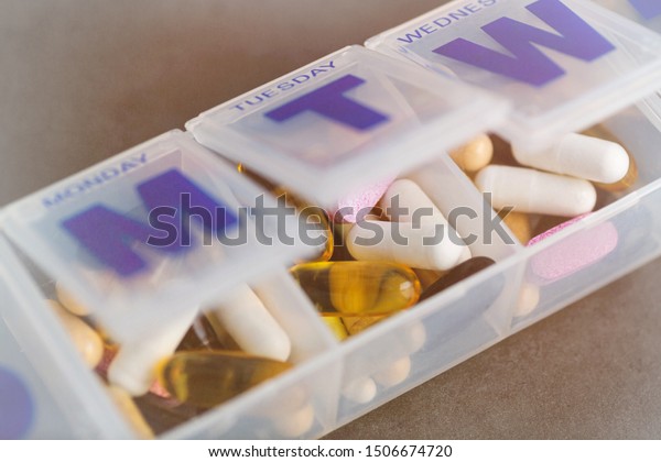 Various Supplements and Vitamins in Plastic Container\
Divided by Day