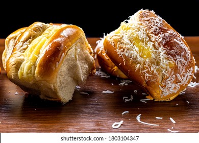 Various sweet breads, with different flavors made with flour, sugar, vanilla cream, guava and grated coconut, on a brown rustic table. Brazilian food.