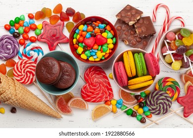 Various sweets assortment. Candy, bonbon, chocolate and macaroons over wooden background. Top view flat lay - Powered by Shutterstock