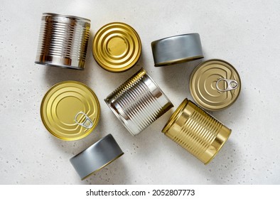 Various Tin Cans For Food Preservation On Gray Concrete Background Top View. Different Canned Food In Steel Cans. Conservation Food, Donation Concept.