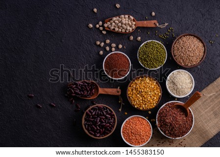 Various type of cereal grains, rice,brown rice, buckwheat, barley, ,millet. Various raw uncooked grains on dark background pulses, grains, seeds and millet.