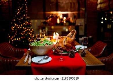 Various type of food such as Roasted Turkey, vegetable salad, french fried and other are prepared and put on table near Christmas tree for celebration of Christmas holiday of family.