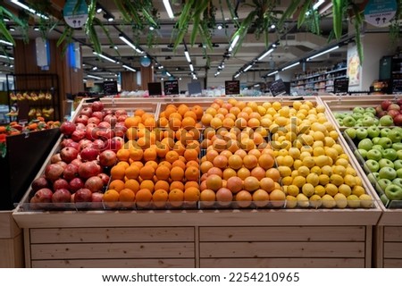 Various type of fresh fruits arrange neatly grocery store. Apple, Orange, Pomegranate, Lemon on rack. 