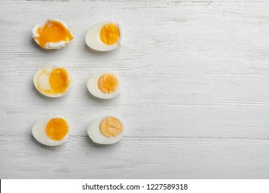 Various types of boiled eggs on white wooden background, flat lay with space for text. Cooking time