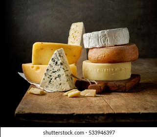 различные виды сыра на деревенском деревянном столе