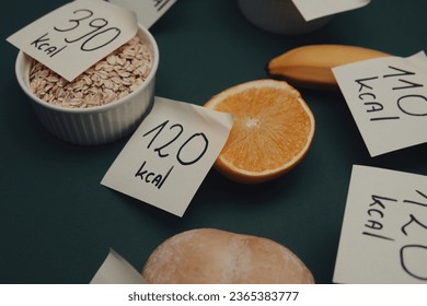 various types of food with labels informing about the amount of calories. Taking care of your diet and calorie intake. Flat lay photo on a green background - Shutterstock ID 2365383777