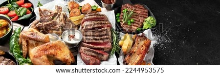 Various types of healthy cooked meat - beef, pork, chicken on a dark background with vegetables and salad. Top view. Panorama with copy space.