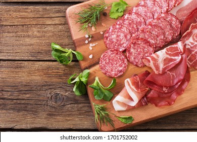 Various Types Of Meat And Sausages On  Wooden Table