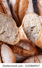 Various Types Of Naturally Fermented Breads Together In A Basket. One Of Them Cut In Half To See Inside.