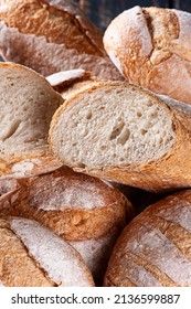 Various Types Of Naturally Fermented Breads Together In A Basket. One Of Them Cut In Half To See Inside.