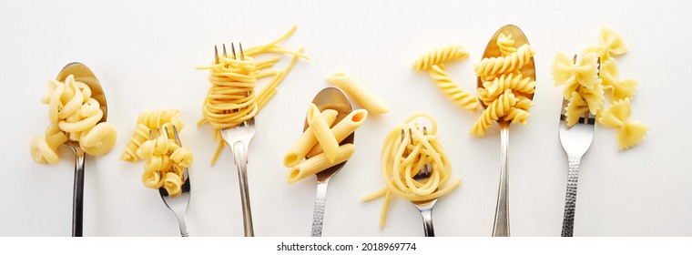 Various types of spaghetti, noodles, and pasta on the forks and spoons in the white background - Shutterstock ID 2018969774