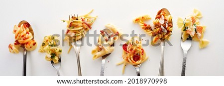 Various types of yummy pasta on spoons and forks (carbonara, spaghetti bolognese, pasta penne arrabiata, fusilli pasta bolognese)