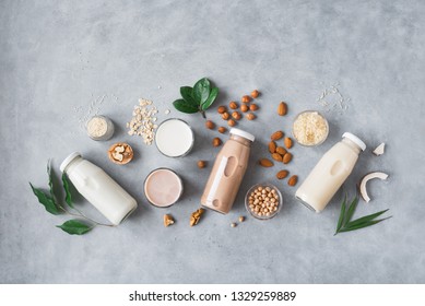Various vegan plant based milk and ingredients on grey, top view, copy space. Dairy free milk substitute drink, healthy eating. - Shutterstock ID 1329259889