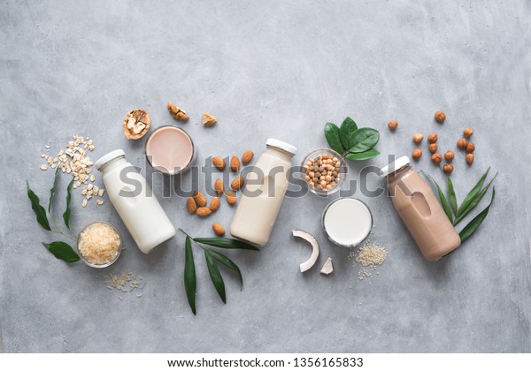 Various vegan\
plant based milk and ingredients, top view, copy space. Dairy free\
milk substitute drink, healthy\
eating.