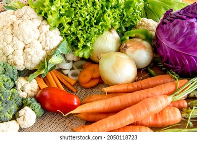 Various vegetables, cauliflower, broccoli, tomato, onion, carrot, lettuce and cabbage.