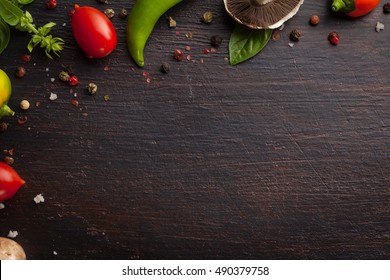 Various Vegetables And Herbs On Dark Wood Table