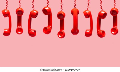 Various Views Of Old Red Telephone Receivers Hanging On Pink Background With Texting Space, Waiting For Phone Call, Customer Service Concept, Vintage Telephone Receiver