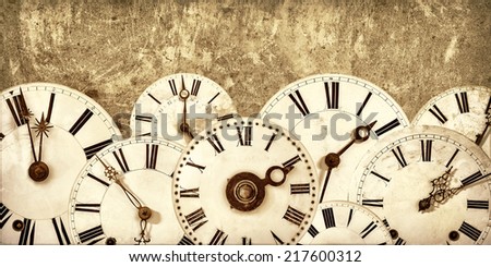 Various vintage clock faces in front of an old concrete wall