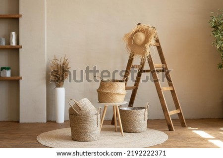 Various wicker baskets for interior decoration stand on the floor in a modern living room.