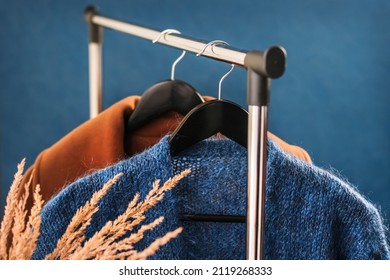 Various Women's Clothing On Hangers On A Rack. Cashmere Jumper And Coat, Stylish Capsule Wardrobe. Classic Women's Fashion Clothes