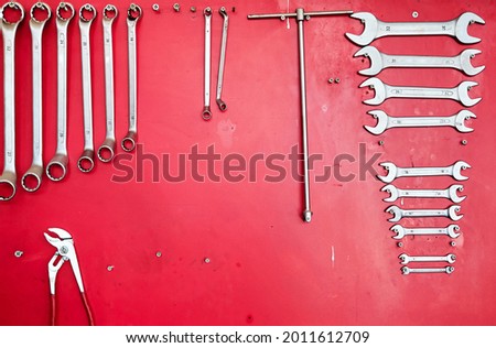 Various work tools hanging on a red stand at the car service workshop.