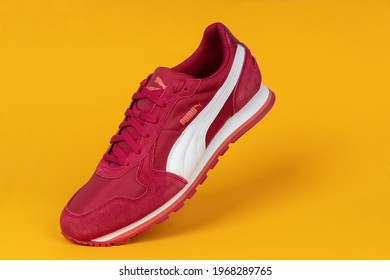 Varna , Bulgaria - APRIL 22, 2021. Red PUMA Sport Shoe On Yellow Background. Puma, A Major German Multinational Company. Product Shot