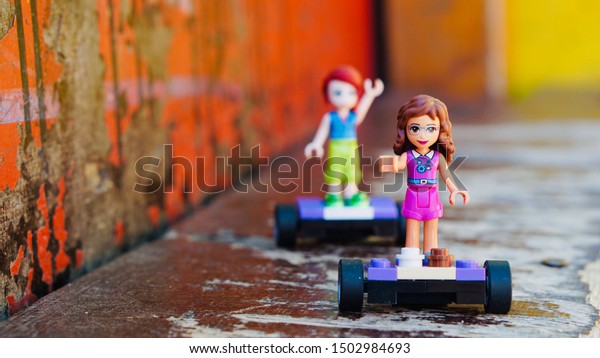 Varna, Bulgaria - September 8th, 2019: Two mini girl\
figures from the Lego Friends series riding their hover boards\
outside. Girlfriends exploring the city outdoors.                  \
           
