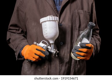 Varnisher With A Paint Gun In His Hand. Car Repair Shop Worker With Tools. Dark Background.