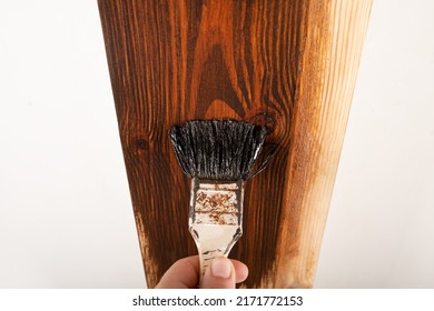 varnishing a doorway, applying varnish with a brush on a wooden surface.
