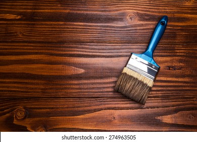 Varnishing a wooden shelf using paintbrush