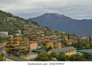 Varone Italy, a charming mountainside town. Colourful buildings with terracotta roofs line the slopes. The majestic mountains in the background add to the breathtaking beauty of this idyllic place. - Powered by Shutterstock