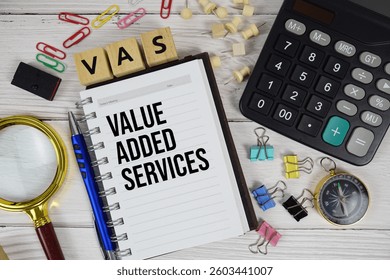 VAS - Value Added Services acronym on notepad, business and financial concept background