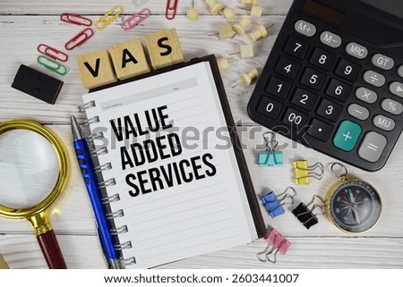 VAS - Value Added Services acronym on notepad, business and financial concept background