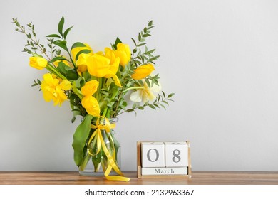 Vase With Beautiful Flowers And Cube Calendar With Date 8 MARCH On Kitchen Counter Near Light Wall. International Women's Day Celebration