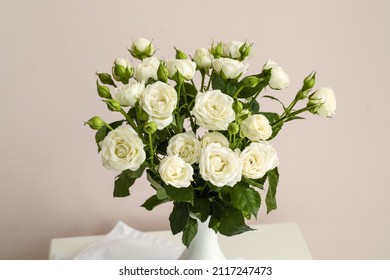 Vase with bouquet of beautiful roses on light background, closeup