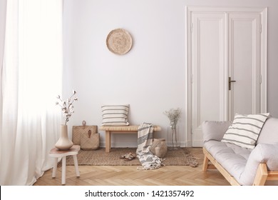 Vase with cotton flower on wooden table next to couch in stylish beige apartment - Shutterstock ID 1421357492