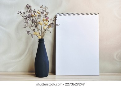 A vase with dried flowers standing on a table near a gray wall w - Shutterstock ID 2273629249